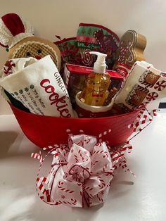 a red basket filled with lots of different items on top of a white countertop