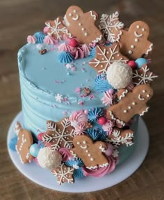 a blue frosted cake topped with lots of gingerbread cookies and snowflakes