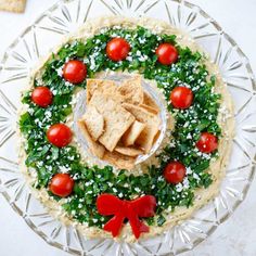 a platter with crackers, tomatoes and spinach on it is shown here