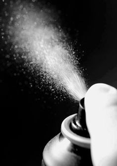 a black and white photo of a sprinkler spraying water onto a teapot