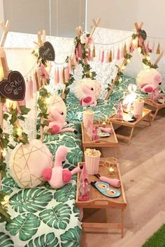 there are many pink flamingos on display in the room with candles and decorations around them