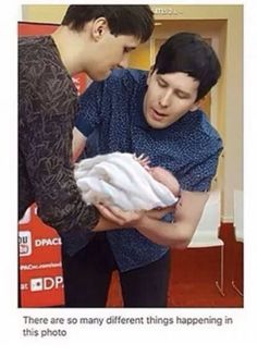 a man holding a baby in his arms with the caption that reads, there are so many different things happening in this photo