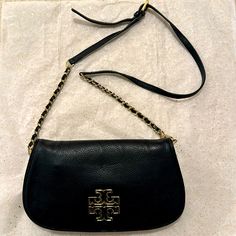 Tory Burch Britten Crossbody Bag; Black With Gold Hardware. Gently Worn. Hardware/Accents In Excellent Condition/Very Small Scratch On Main Emblem. Handbag In Excellent Condition. Detachable Shoulder Strap But Can Be Worn As A Clutch. No Smoking Home. Tory Burch Britten, Crossbody Bag Black, Tory Burch Bags, Tory Burch Bag, Gold Hardware, Tory Burch, Crossbody Bag, Shoulder Strap, Bag Lady