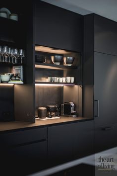 a kitchen with black cabinets and shelves filled with dishes