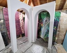 two archways with paintings on them in a room that is being renovated and remodeled