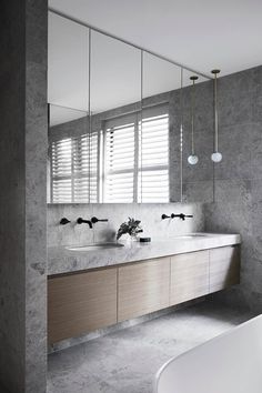 a bathroom with two sinks, mirrors and a bathtub in the middle of it