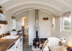 a kitchen and living room in a tiny home with wood floors, white walls and ceilings