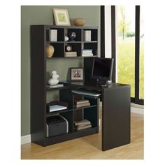 a computer desk with bookshelf and shelves in front of a large window on the wall