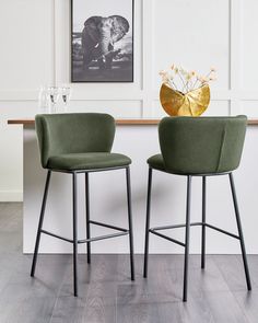 two green chairs sitting next to each other on top of a hard wood floored floor