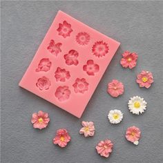 some pink and white flowers are next to a cookie sheet