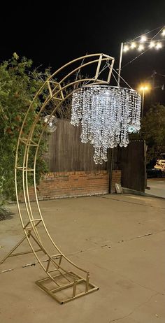 a chandelier in the shape of a spiral with lights hanging from it's sides