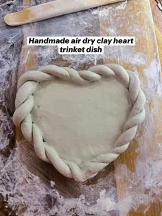 a heart shaped dough sitting on top of a wooden table