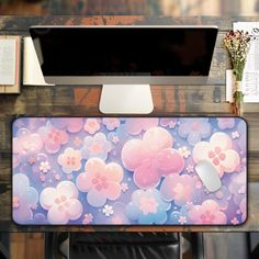 a computer monitor sitting on top of a desk next to a keyboard and mouse pad