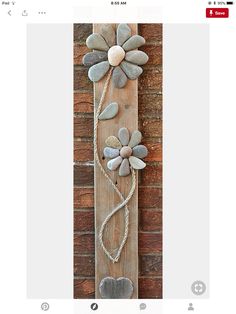 a wooden sign with flowers on it and rope attached to the side of it,