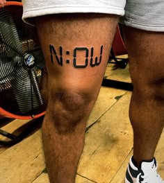 a man's leg with the word now written on it