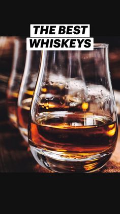 three glasses filled with liquid sitting on top of a wooden table