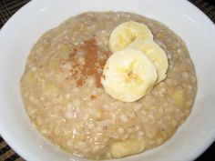 a white bowl filled with oatmeal and banana slices