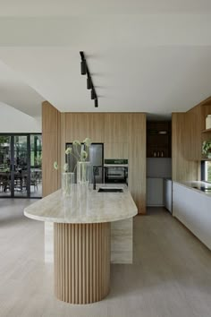 a kitchen with an island in the middle of it and lots of wood on the walls