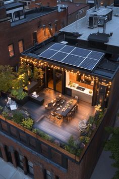 an aerial view of a rooftop deck with lights and patio furniture on the upper level