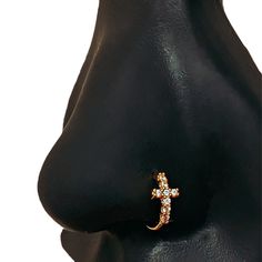 a close up view of a nose with a cross on it's nose ring