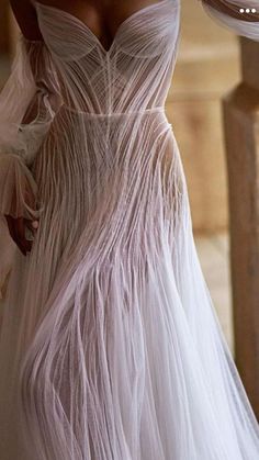 a woman in a long white dress standing on stairs