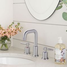 a bathroom sink with two faucets and soap dispenser next to it