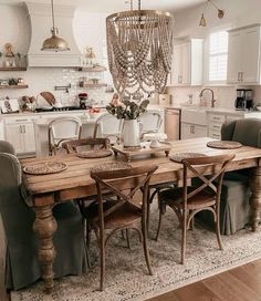 a dining room table with chairs and a chandelier hanging from the ceiling