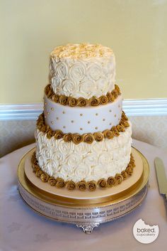 a three tiered cake sitting on top of a table next to a knife and fork