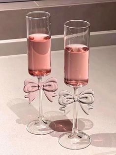 two wine glasses with pink liquid in them