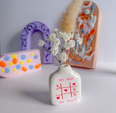 a vase with flowers in it sitting on a table next to other toys and decorations