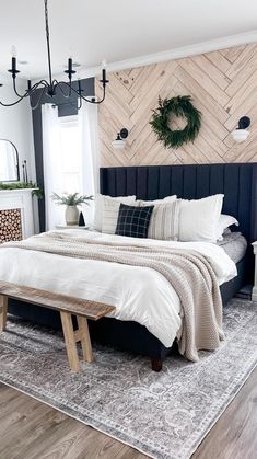 a bed room with a neatly made bed next to a window and a wreath on the wall