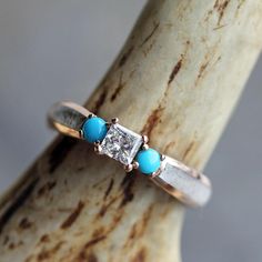 a close up of a ring with two stones on it