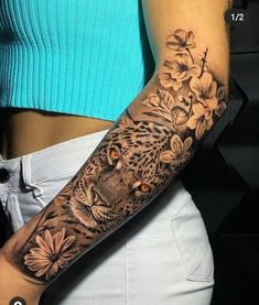 a woman with a tattoo on her arm has a leopard and flowers tattooed on it