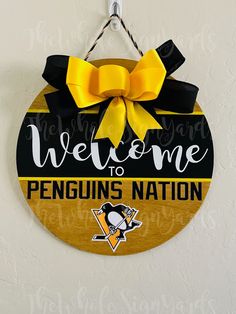 a sign that says welcome to penguins nation hangs on the wall in front of a white wall