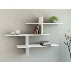 two white shelves with books and plants on them