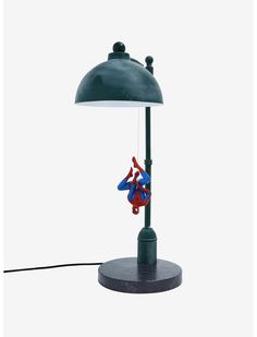 a lamp with a spider man hanging from it