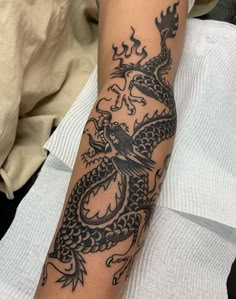 a black dragon tattoo on the arm