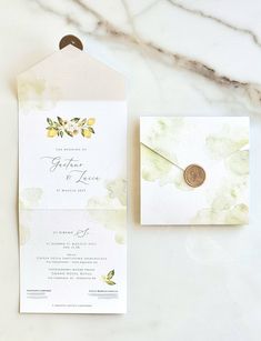 the wedding stationery is laid out on top of the marble table and next to it's envelope