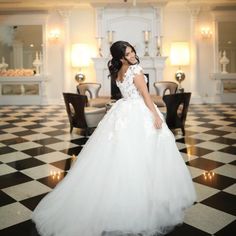 a woman in a white wedding dress standing on a black and white checkered floor