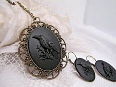 JUST LISTED Bronze settings Black on Black CROW Gothic Rockabilly Earring Set Cameo Necklace Pendant Victorian Jewelry substantial in size at just a little over 2 INCHES Long Center is 40mmx30mm **MATCHING ITEMS IN OUR STORE BADGE HOLDER BROOCH HAIR PINS - CLIPS** **PLEASE NOTE THIS LISTING IS FOR THE NECKLACE ONLY **thank you for taking the time to look at our items. Each item is handcrafted and attention to detail - We send each item in bubble packaging and with tracking to make sure items arr Rockabilly Earrings, Black Raven, Black Crow, Cameo Necklace, Black Skulls, Black On Black, Black Chain, Victorian Jewelry, Badge Holder