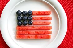 blueberries and watermelon arranged in the shape of an american flag on a plate