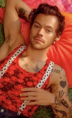 a man laying on top of a green floor next to a red pillow