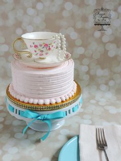 there is a cake that has been decorated with tea cups and pearls on the top