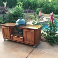 an outdoor bbq grill in the middle of a patio with tables and umbrellas