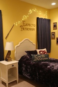 a bedroom decorated in yellow and purple with pictures on the wall