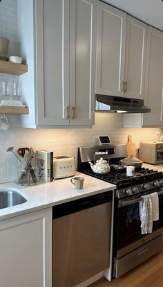 a kitchen with white cabinets and stainless steel appliances