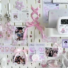 there are many items on the wall with pink ribbons and bows, including an alarm clock