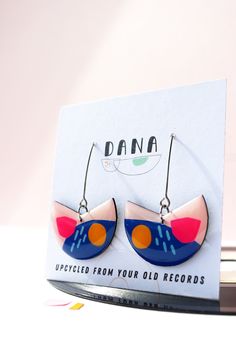 a pair of dana earrings on top of a record