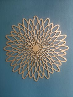 a wooden cutout of a flower on a blue wall in the shape of a circle