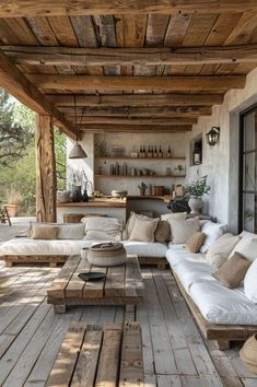 an outdoor living area with couches, tables and lamps on the outside wall is covered in wood planks